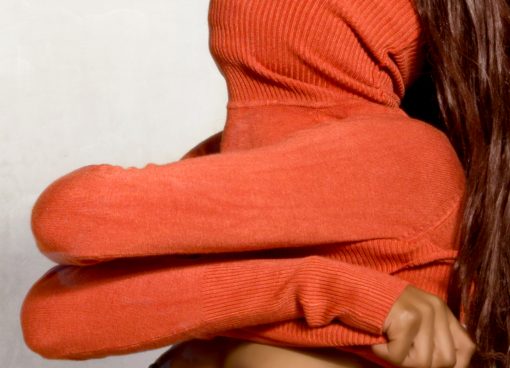 Gesicht einer Frau vom roten Pullover verdeckt