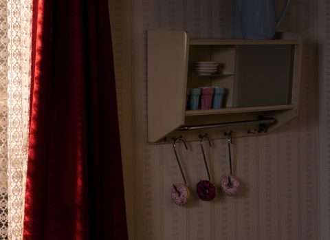 Donuts am Fleischerhaken unter einem Wandregal