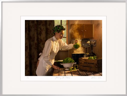Köchin mit Broccoli und dampfendem Topf in einer alten Küche