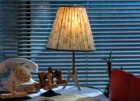 Foto mit Wählscheibentelefon und Schirmlampe.