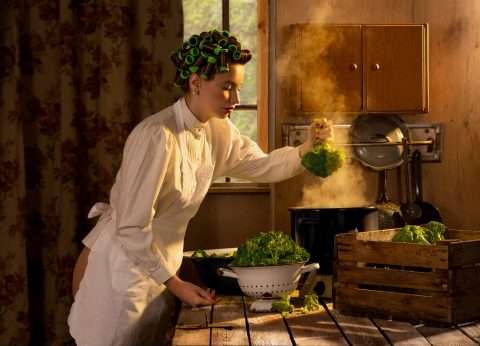 Horst Kistner | Postkarte | Yearning for Greens - Auf der Postkarte von Horst Kistner mit dem Titel Yearning for Greens ist eine Frau mit Brokkoli zu sehen