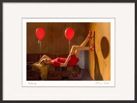 Frau in rotem Kleid liegt entspannt mit Ballons im Licht – Fotografie Balance von Horst Kistner, Sinnbild für die Leichtigkeit des Seins und Bild der Ausgeglichenheit