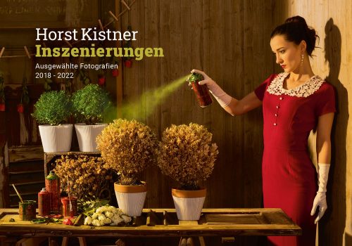 Horst Kistner Inszenierungen Katalog 2022 Titelbild zeigt eine Frau die verwelkte Pflanzen mit Farbspray grün einfärbt