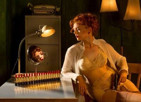 Die Postkarte von Horst Kistner mit dem Titel Decoy ist eine Erotische Postkarte der feinsten Art. Eine Frau sitzt in reizender Unterwäsche mit einem Revolver in ihrem Büro. Wen erwartet sie?