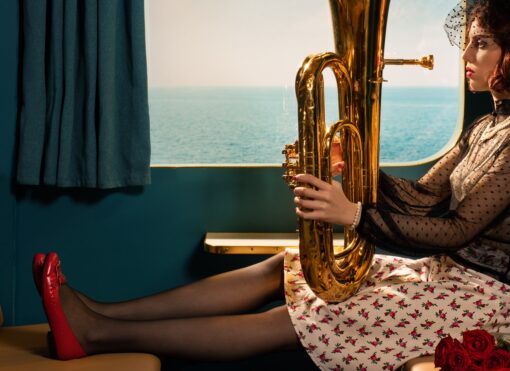 Horst Kistner La Traversata photography Detail 3 zeigt eine Frau an einem Fenster eines Kreuzfahrtschiffes bei der Überquerung des Atlantik. Sie hält eine Tube und gehört wahrscheinlich zum Bordorchester.