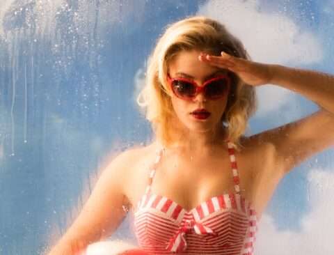 Das Detail 1 von Horst Kistner Fotografie Eycatcher zeigt die Frau im Badeanzug durch das Fenster in einen Innenraum schauend.