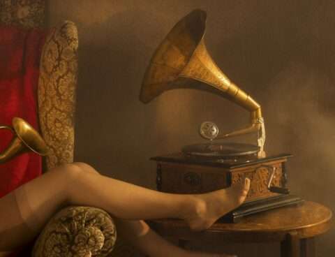 Horst Kistner La Femme Bruyante ist eine erotisch aufgeladene Fotografie für Liebhaber. Auf diesem Detail sind die Beine einer Frau zu sehen. Und ein altes Grammophon.