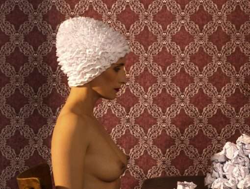 Die Fotografie von Horst Kistner The Paper Rose zeigt im Detail die nackte Frau am Tisch mit einer Badekappe. Eine surreale Situation mit hoher Strahlkraft.