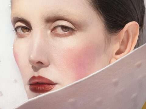 Das Detail der Fotografie von Somy Samani Screened zeigt eine Frau im roten Kleid. Sie blickt direkt, fast herausfordernd aus dem Bild. Ihre Züge sind fein, beinahe regungslos, ihre Haut ist blass, die Lippen tiefrot – ein Bild von Würde und Entschlossenheit.