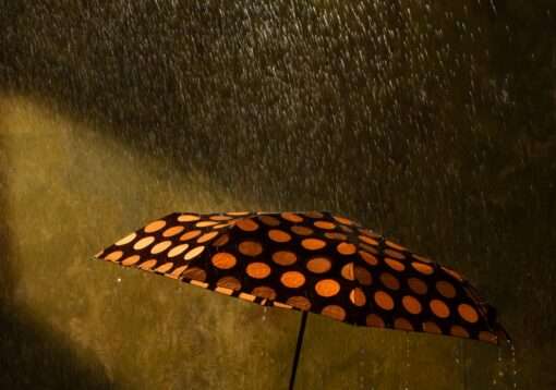 Horst Kistner Monsun Fotografie zeigt in diesem Detail den aufgespannten Schirm, den sich die Frau über den Kopf hält. Denn es regnet in ihr Badezimmer.