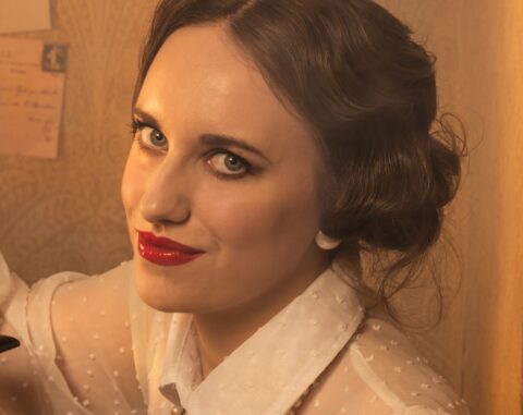 Porträt einer Frau mit roten Lippen und Perlenschmuck aus Horst Kistners Fotografie „La Gravure“ – ein Sinnbild für böse Frauen mit schelmischem Blick in der Kunst, elegant, selbstbewusst und verführerisch.