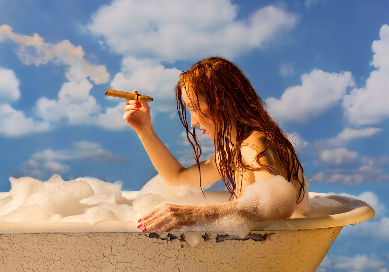 Frau mit Zigarre im Schaumbad vor blauem Wolkenhimmel – Fotokunst von Horst Kistner.